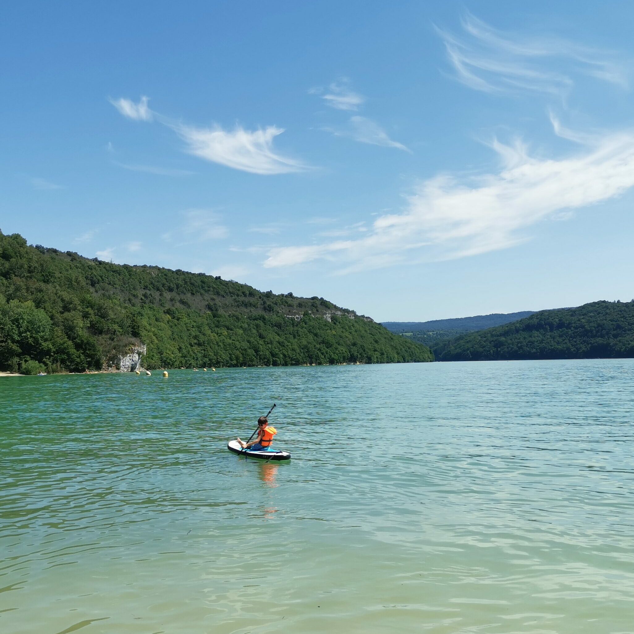 photo du lac de Vouglans avec un enfant faisant du paddle